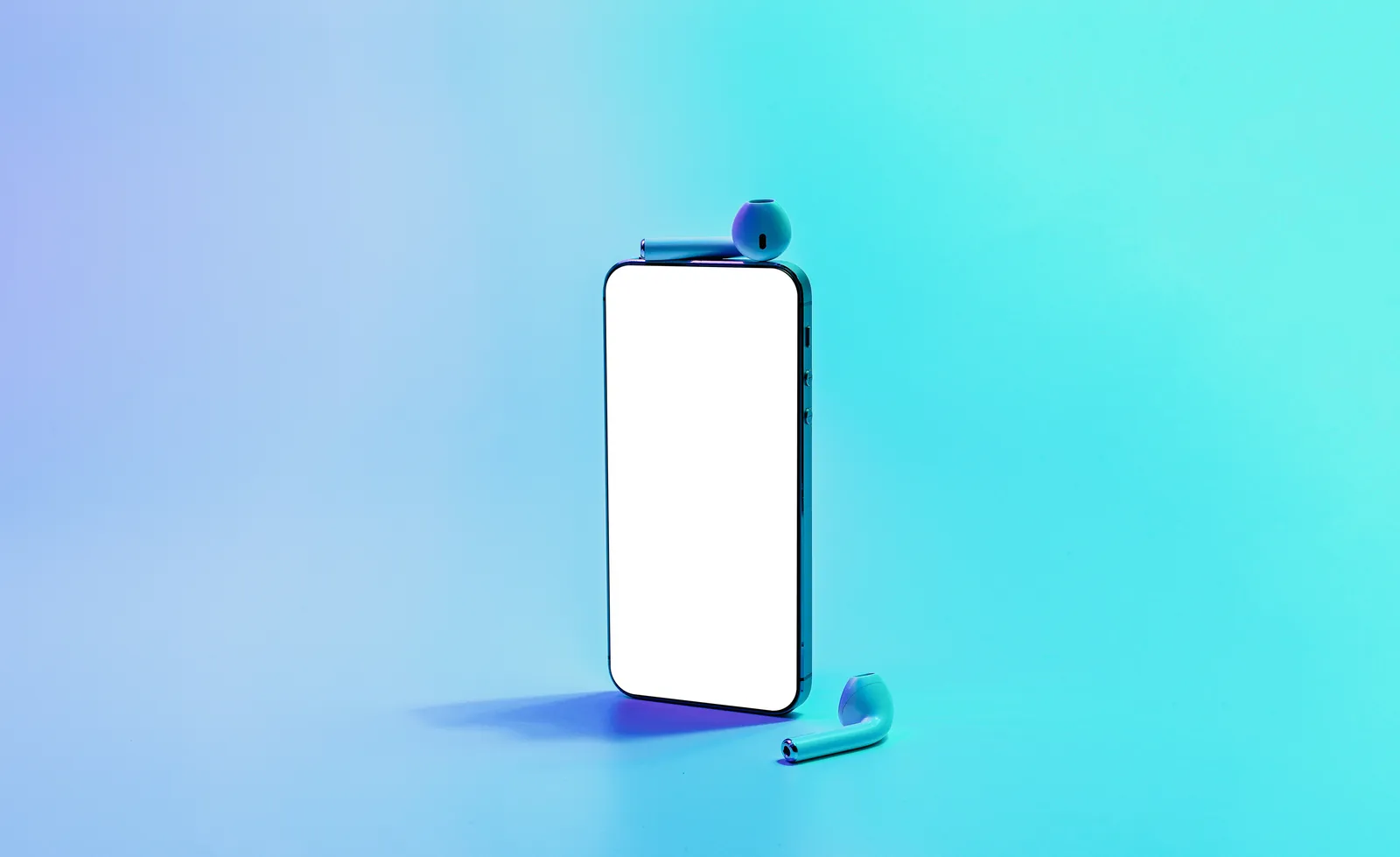 A phone standing upright beside a pair of wireless earbuds