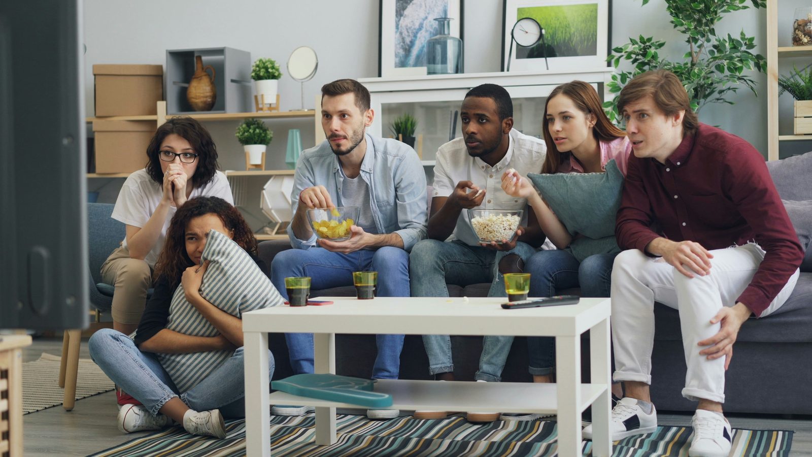 Friends watching a film together on streaming TV at home